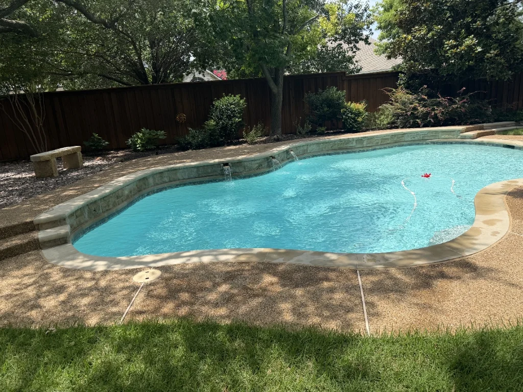 Pool technician cleaning residential pool